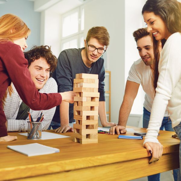 A group of young adults enjoying themselves and building friendships by playing board games.