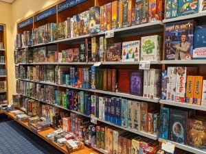 A shelf filled with different genres of Houston boardgames.